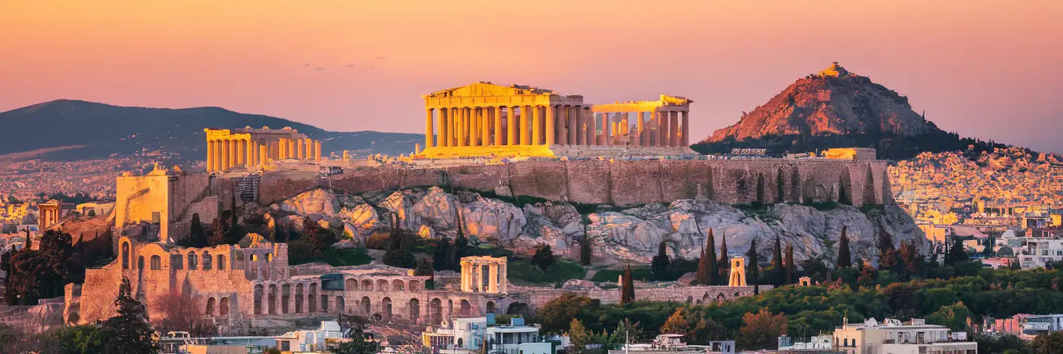 The Acropolis and Parthenon rising above Athens at golden hour with Lycabettus Hill in the distance