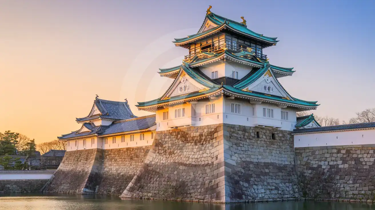 Osaka Castle's main tower bathed in warm golden hour light with massive stone walls and moat reflection