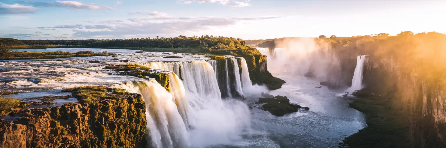 Iguazu Falls thundering through subtropical rainforest on the Argentine side at golden hour