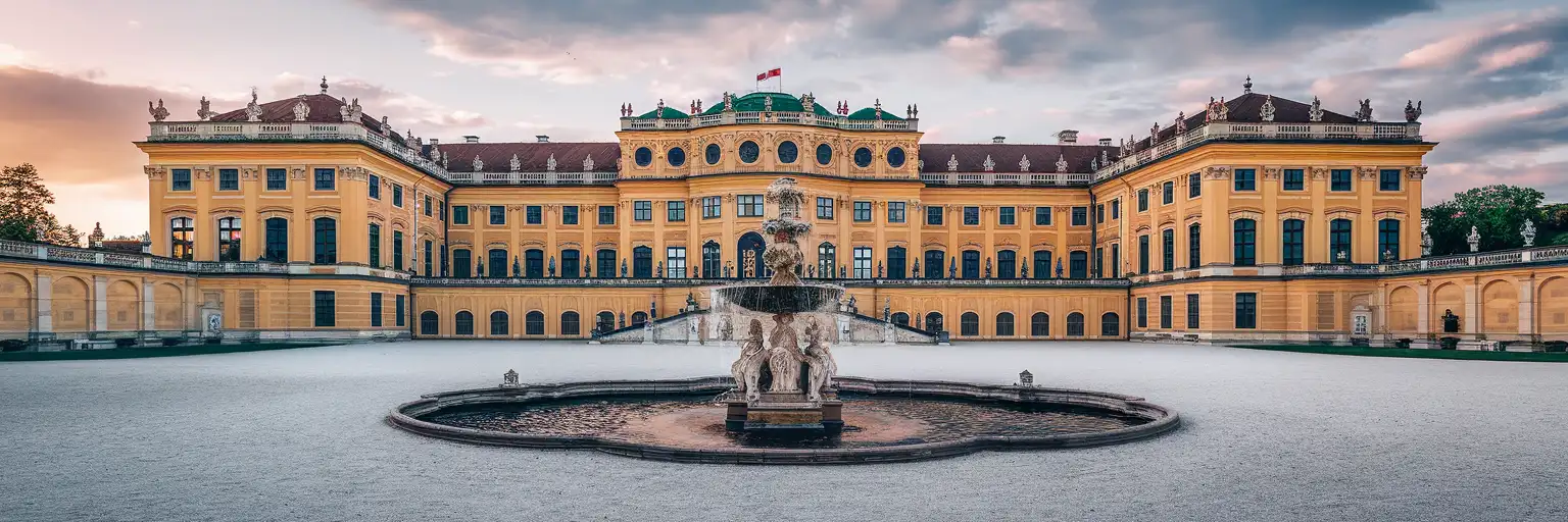 The grand ochre-yellow Baroque facade of Schönbrunn Palace in Vienna at golden hour with formal gardens beyond