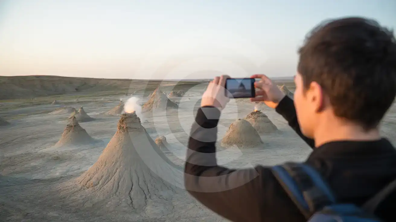 Gezin in Highland Park in Bakoe met smartphone die de Flame Towers en het uitzicht op de Kaspische Zee vastlegt