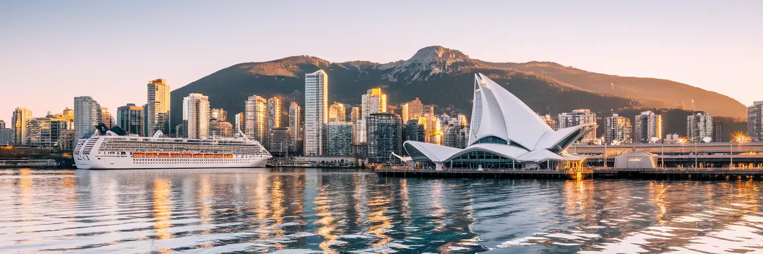 Vancouver skyline with Canada Place sails and North Shore Mountains at golden hour from Coal Harbour
