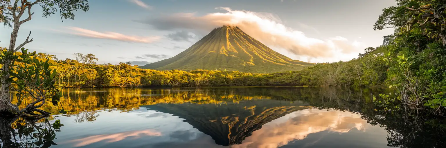 Arenal Volcano rising above Lake Arenal and rainforest canopy at golden hour in Costa Rica