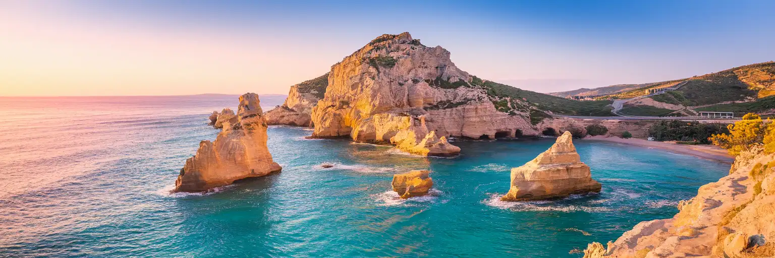 Petra tou Romiou (Aphrodite's Rock) rising from the turquoise Mediterranean waters along the Cyprus coastline at golden hour