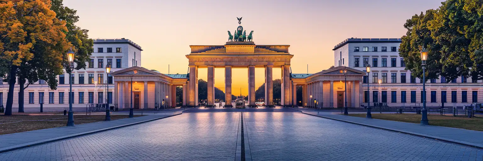 Wide golden-hour view of Brandenburg Gate and the Unter den Linden boulevard in Berlin, Germany
