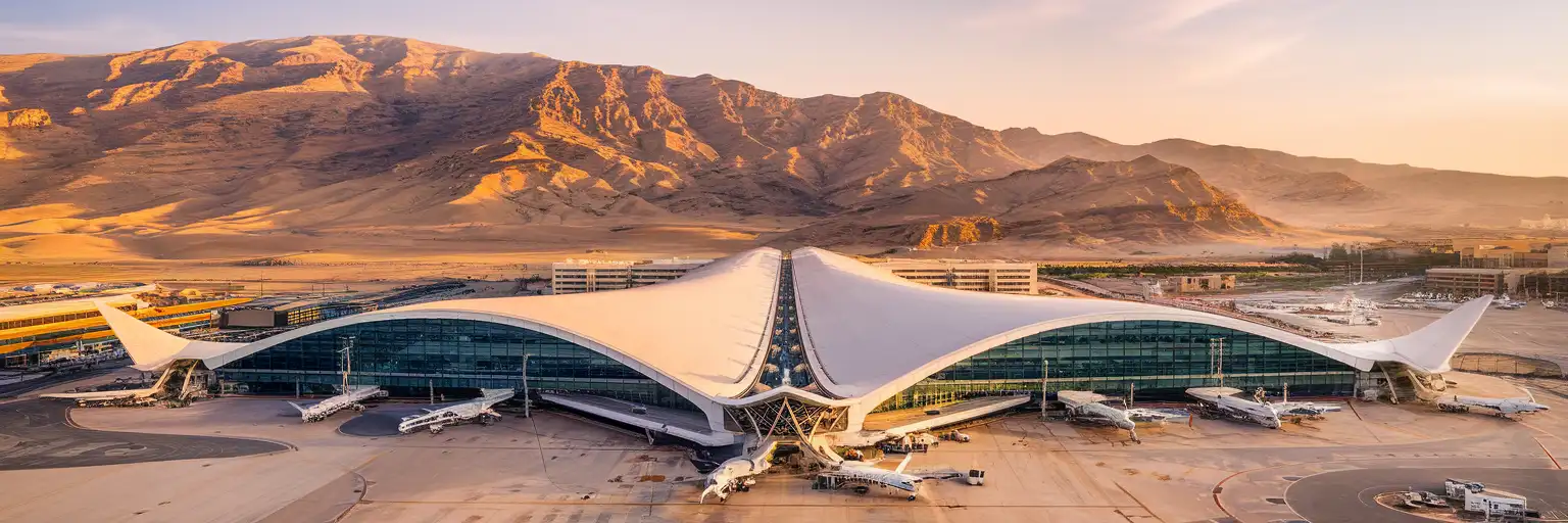 Sharm El Sheikh International Airport Terminal 1 exterior with curved white roofline and Sinai mountains at golden hour