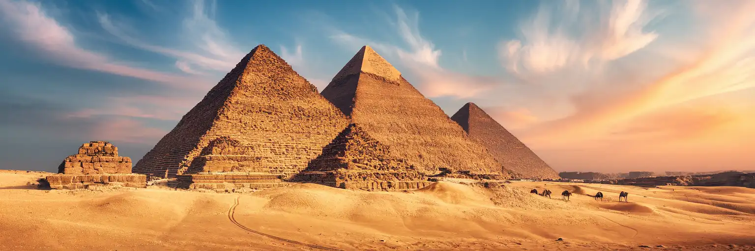 The Great Pyramid of Khufu and Pyramid of Khafre rising from the Giza Plateau at golden hour with desert sand in the foreground