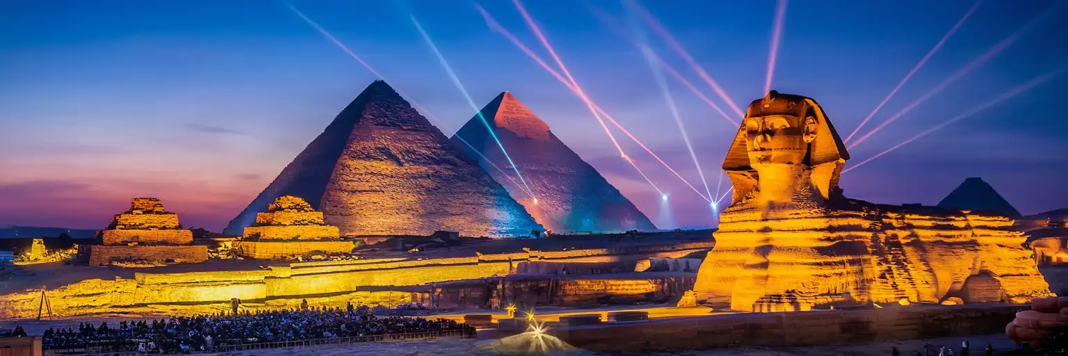 The Great Pyramid and Sphinx illuminated by colored spotlights during the Sound and Light Show at Giza Plateau