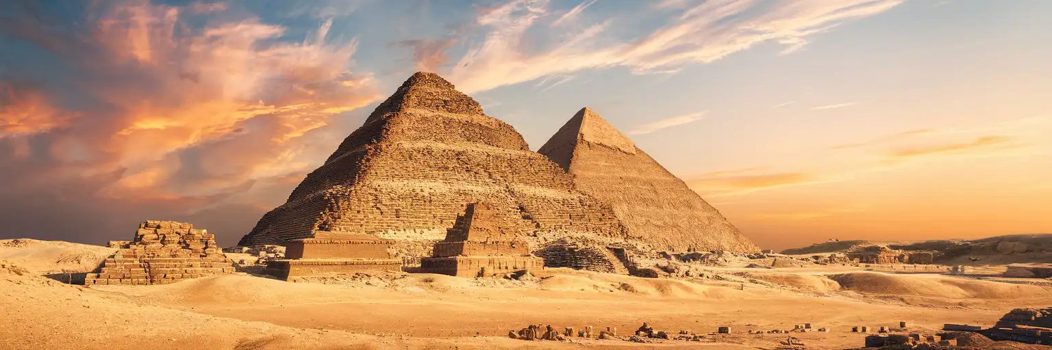 The Step Pyramid of Djoser at Saqqara Necropolis rising in tiered limestone layers above the Egyptian desert plateau at golden hour