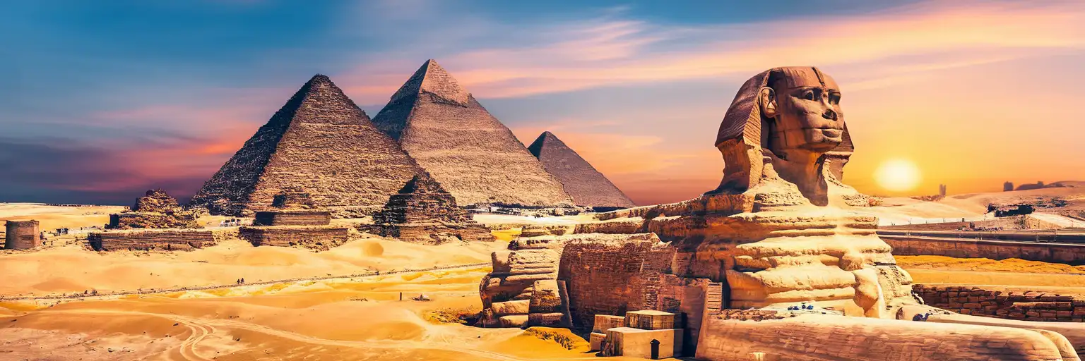 The Great Pyramid of Giza and Sphinx at golden hour with the desert plateau stretching toward Cairo