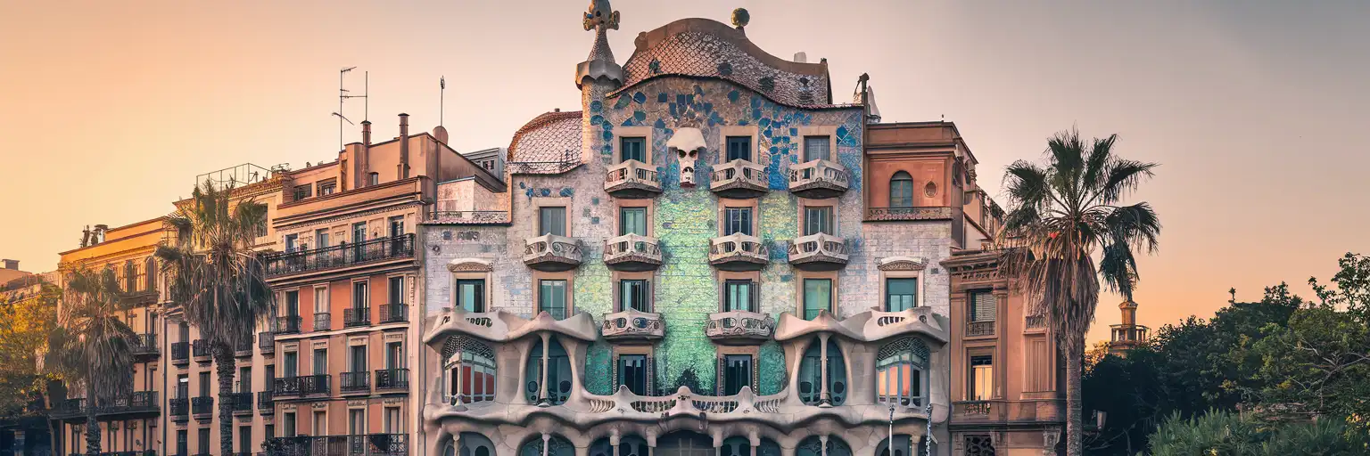 The colorful trencadís mosaic facade of Casa Batlló on Passeig de Gràcia at golden hour in Barcelona