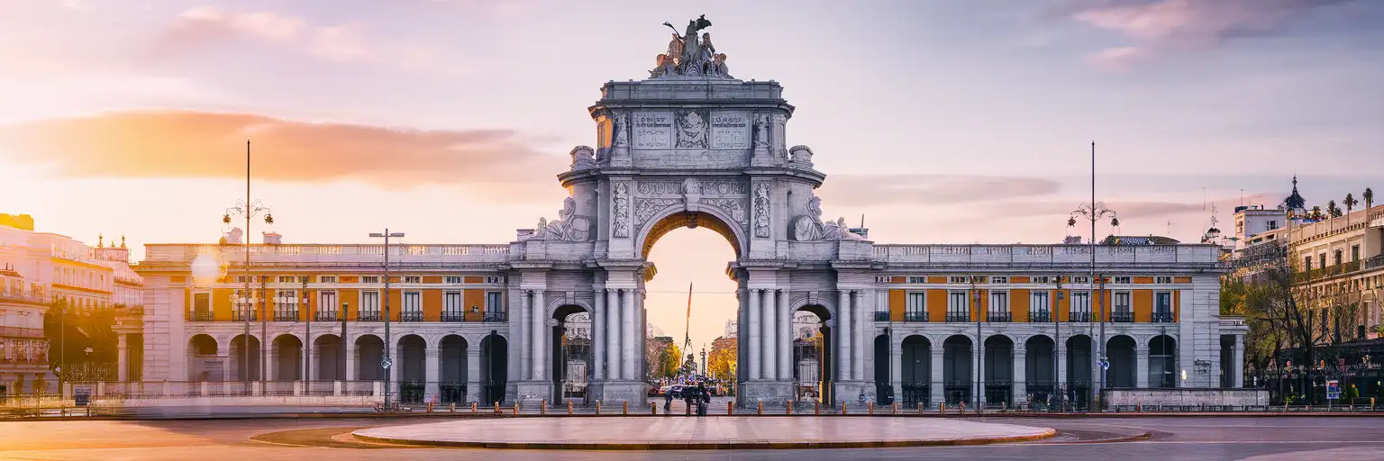 Golden-hour exterior view of Puerta de Alcalá in Madrid with the full triumphal arch and surrounding plaza