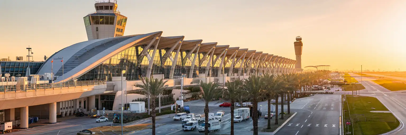 Wide exterior view of Valencia Airport terminal and control tower at golden hour in Valencia, Spain