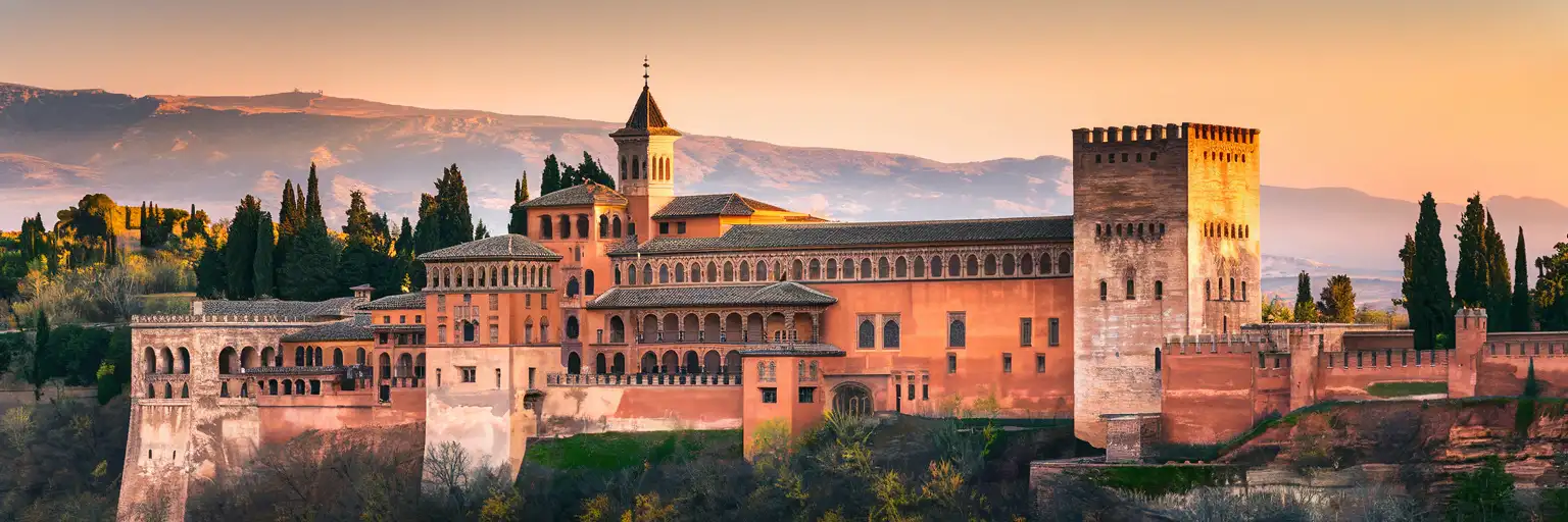 Hotel Alhambra Palace facade with Moorish-revival architecture overlooking Granada at golden hour