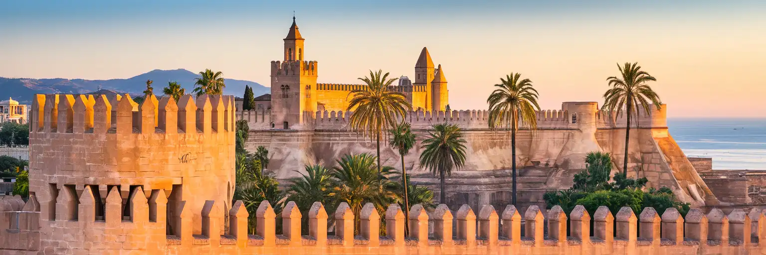 The Alcazaba fortress rising above Malaga's historic center with Mediterranean Sea views at golden hour