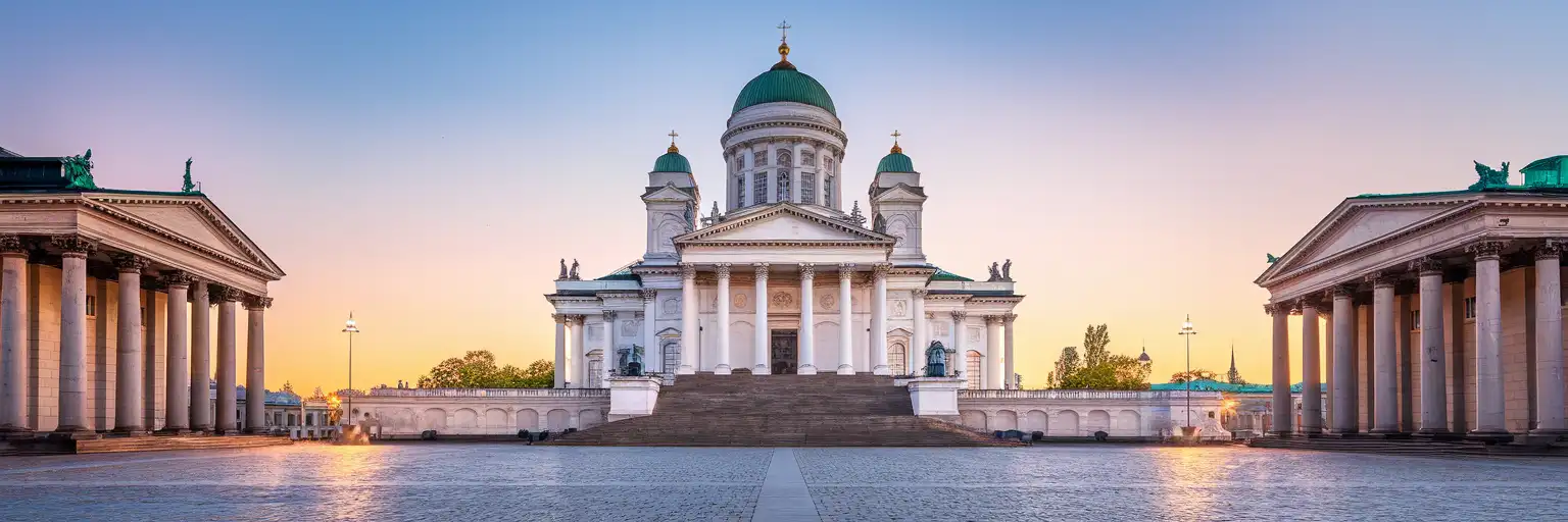 Helsinki Cathedral rising above Senate Square at golden hour with its white neoclassical facade and green copper domes