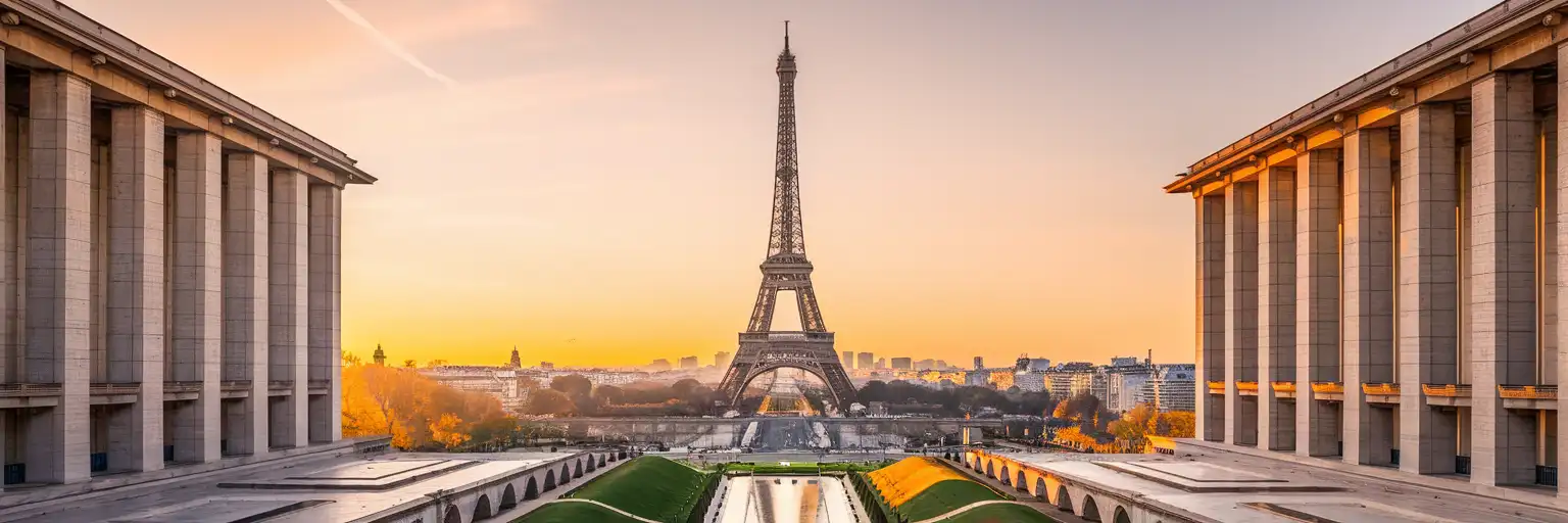 The Eiffel Tower rising above the Paris skyline at golden hour, viewed across the Seine River from Trocadéro