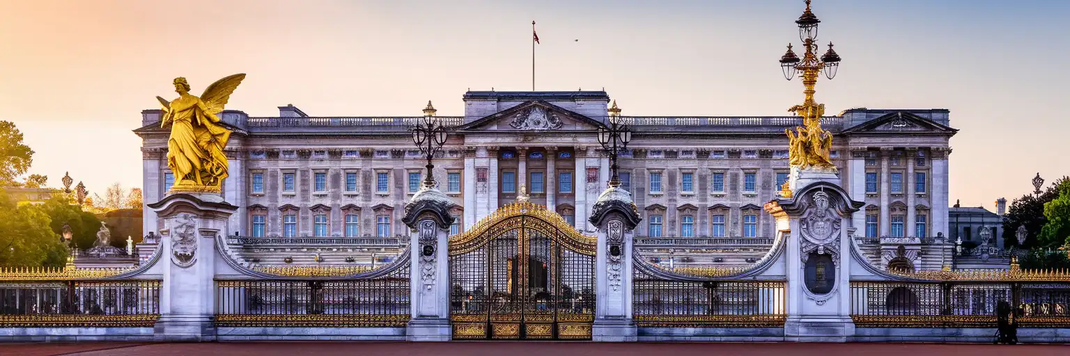 Buckingham Palace east facade at golden hour viewed from the Victoria Memorial with The Mall stretching toward Admiralty Arch