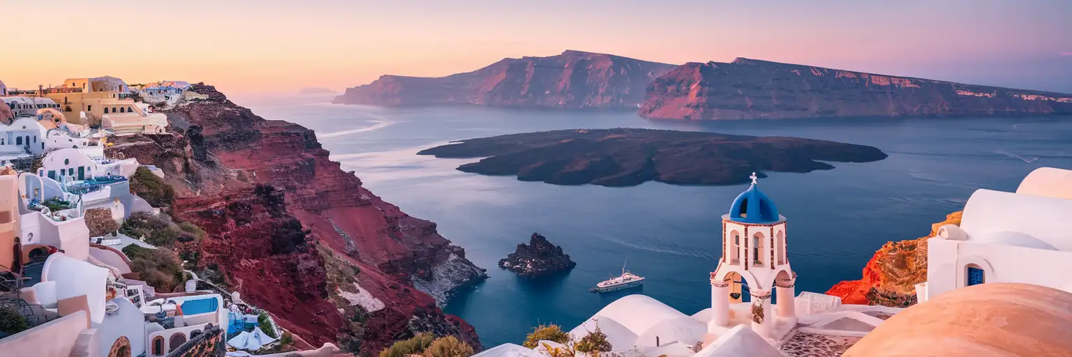 Panoramic view of Santorini Caldera at golden hour with whitewashed villages on the volcanic cliffs and Nea Kameni island in the center