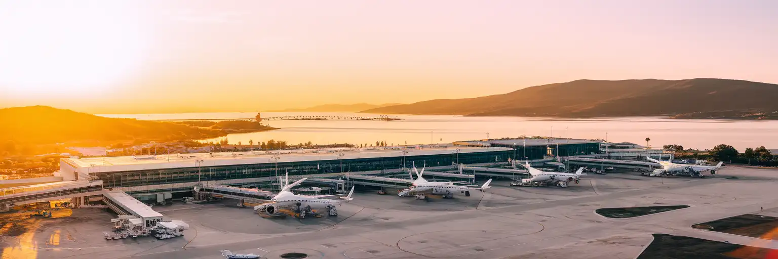 Wide exterior view of Corfu International Airport beside the lagoon at golden hour in Corfu, Greece