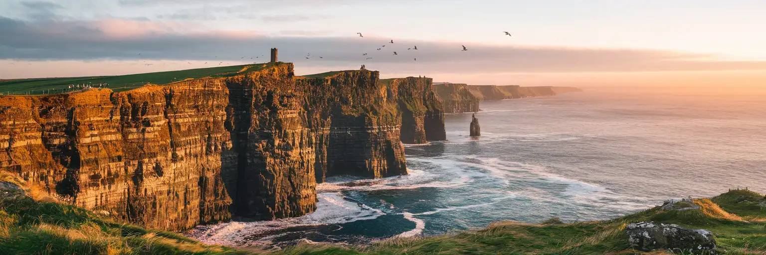 The Cliffs of Moher rising from the Atlantic Ocean along Ireland's County Clare coastline at golden hour
