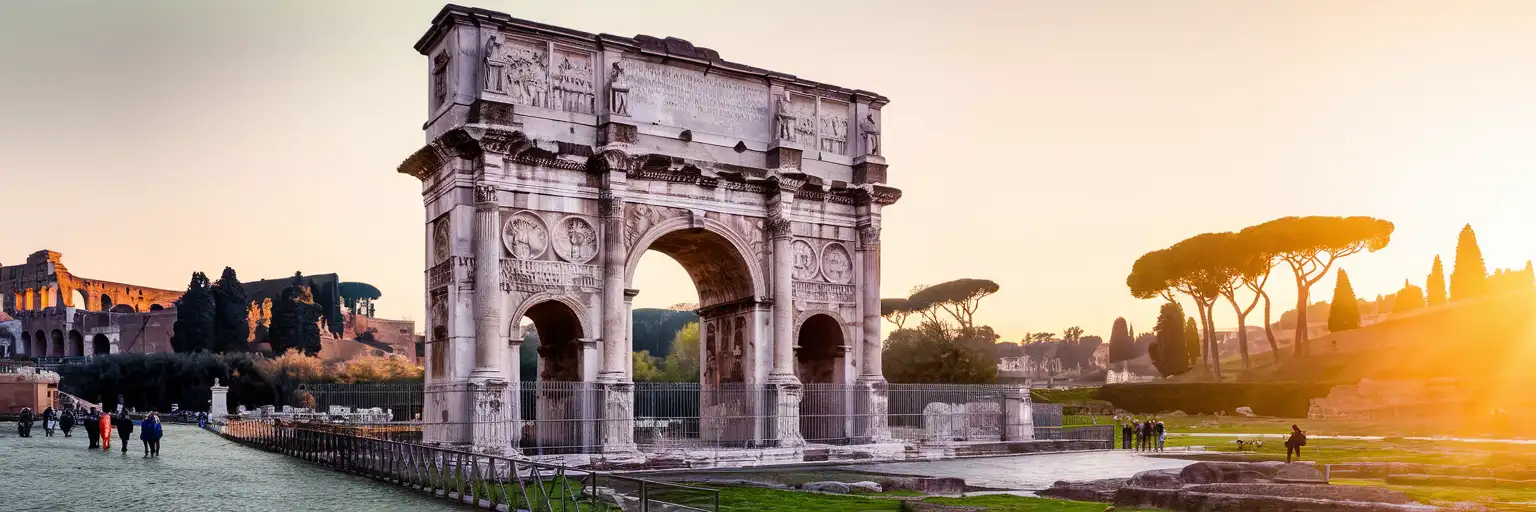 Wide sunset view of the Arch of Constantine in Rome with the surrounding archaeological plaza
