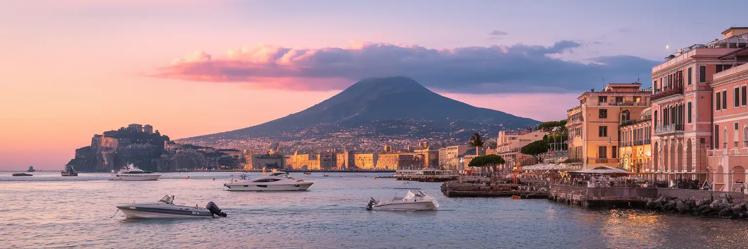 Mount Vesuvius rising behind the Bay of Naples waterfront at golden hour with traditional fishing boats in the harbor