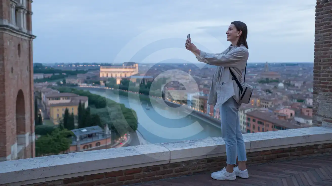 Solo female traveler photographing the Verona panorama from Castel San Pietro viewpoint at blue hour twilight