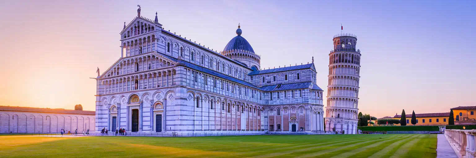 The Leaning Tower of Pisa and Pisa Cathedral in the Piazza dei Miracoli at golden hour with warm sunlight on white marble