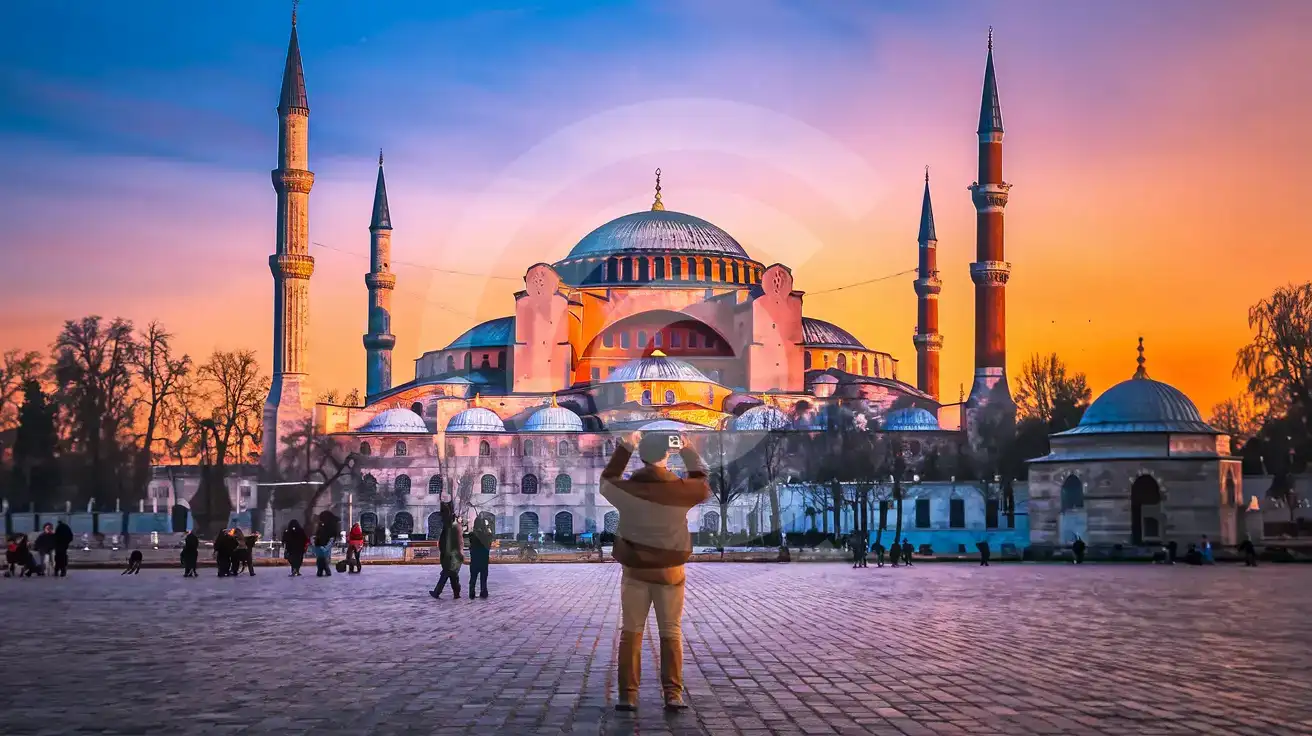 Traveler photographing Hagia Sophia Grand Mosque at golden hour in Istanbul Turkey