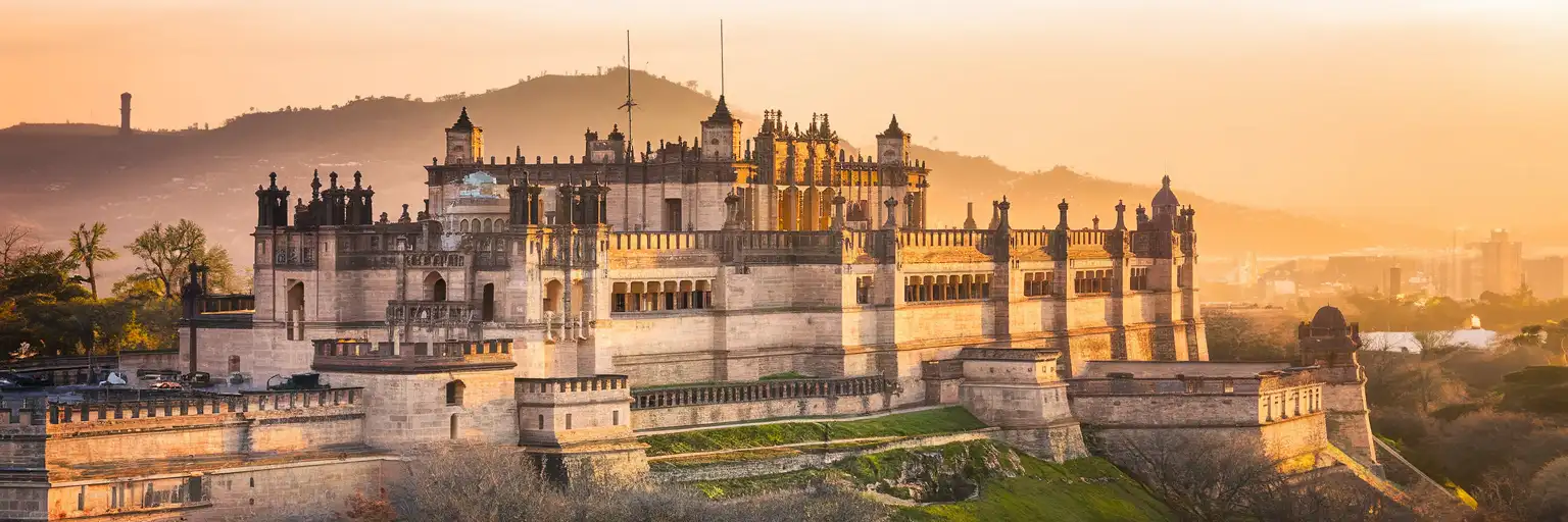 Wide exterior view of Castillo de Chapultepec on Chapultepec Hill in Mexico City at golden hour