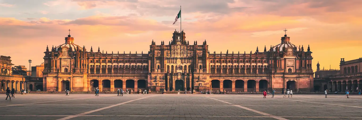 Wide exterior view of Palacio Nacional facing the Zocalo in Mexico City at sunset