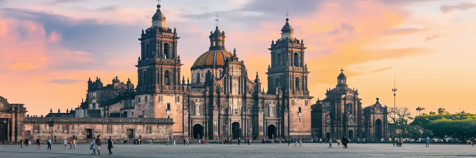 Wide exterior view of the Metropolitan Cathedral of Mexico City on the Zócalo at golden hour