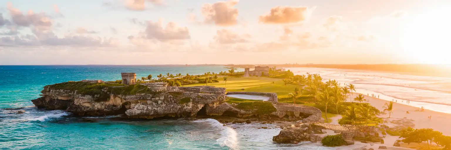 Wide exterior view of Tulum National Park on the Caribbean coast in Tulum, Mexico at sunset