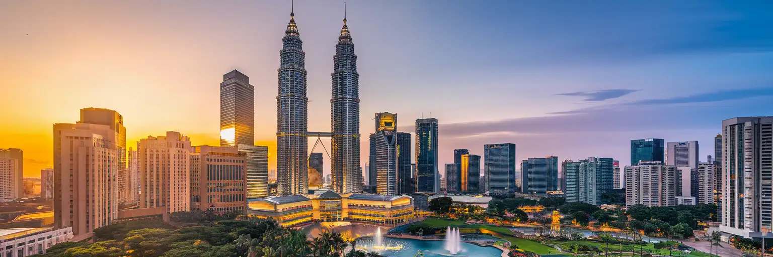Petronas Twin Towers rising above KLCC Park at golden hour in Kuala Lumpur, Malaysia