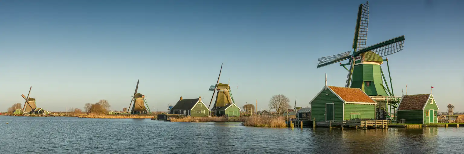 O Rijksmuseum em Amsterdã ao entardecer com ciclistas passando por seu icônico arco
