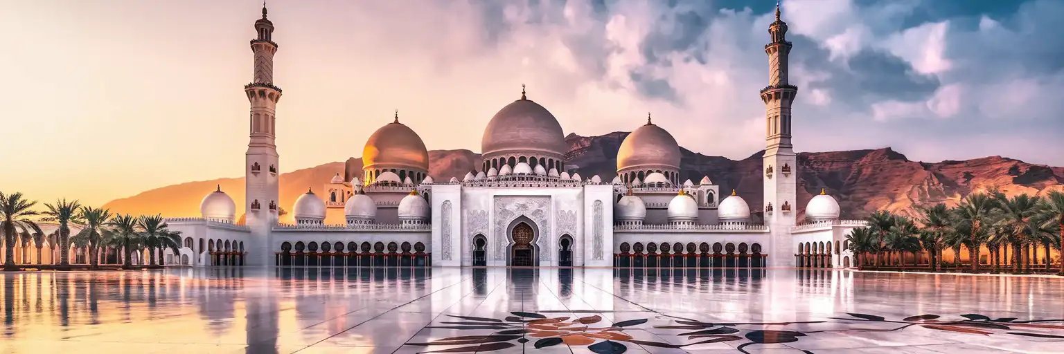 Sultan Qaboos Grand Mosque in Muscat at golden hour with white marble domes and Hajar Mountains behind
