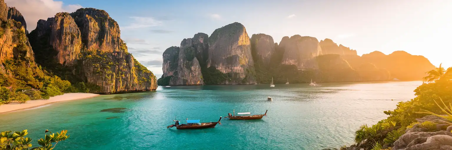 Maya Bay on Koh Phi Phi Leh with towering limestone cliffs and turquoise Andaman Sea waters at golden hour