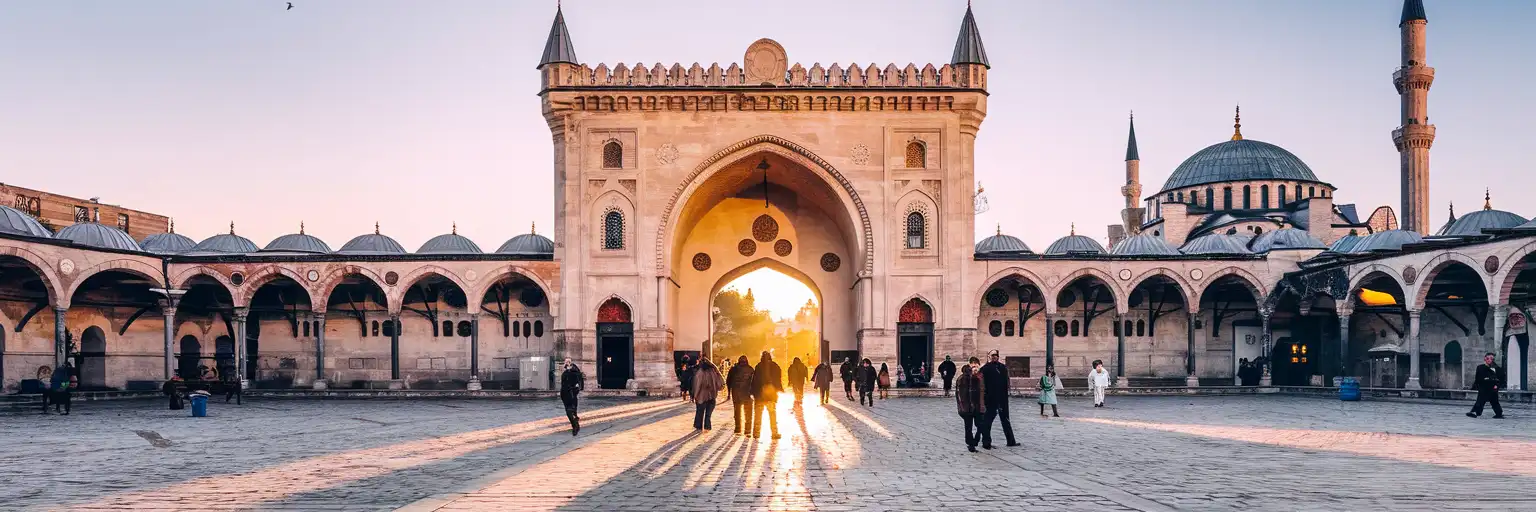 Nuruosmaniye Gate entrance to the Grand Bazaar in Istanbul at golden hour with Ottoman archway and adjacent mosque dome