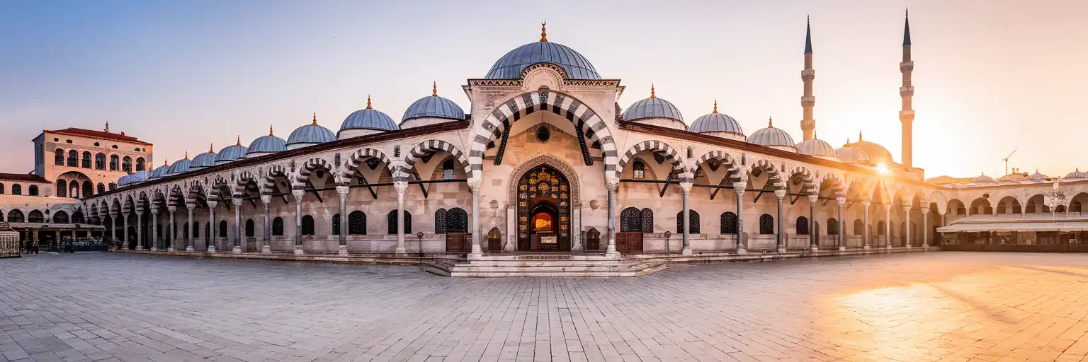 Wielkie osmańskie wejście do Spice Bazaar w Stambule o złotej godzinie z widocznym minaretem Nowego Meczetu w tle