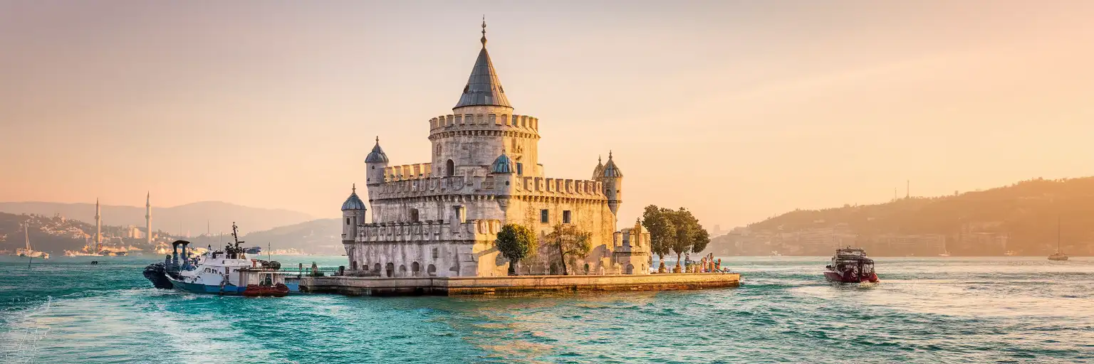 Maiden's Tower rising from the Bosphorus Strait at golden hour with the Asian shore of Istanbul visible behind