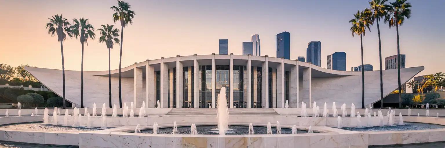 Piața The Music Center și colonada Dorothy Chandler Pavilion la ora de aur, cu silueta orașului Los Angeles în fundal