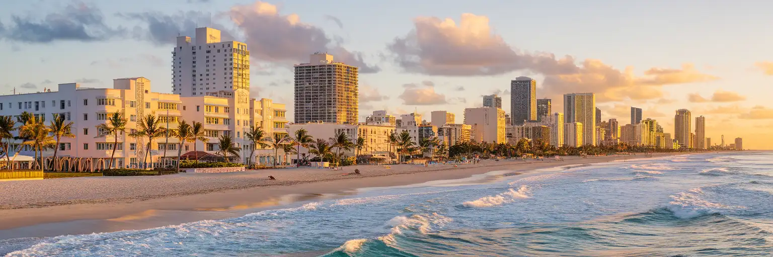 Miami Beach skyline and Art Deco hotels along Ocean Drive at golden hour with palm trees and Atlantic Ocean