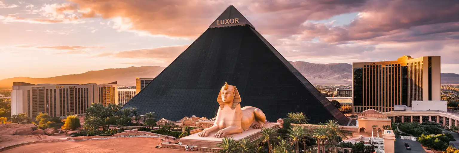 The iconic black glass pyramid of Luxor Hotel and Casino with its Sphinx replica on the Las Vegas Strip at golden hour