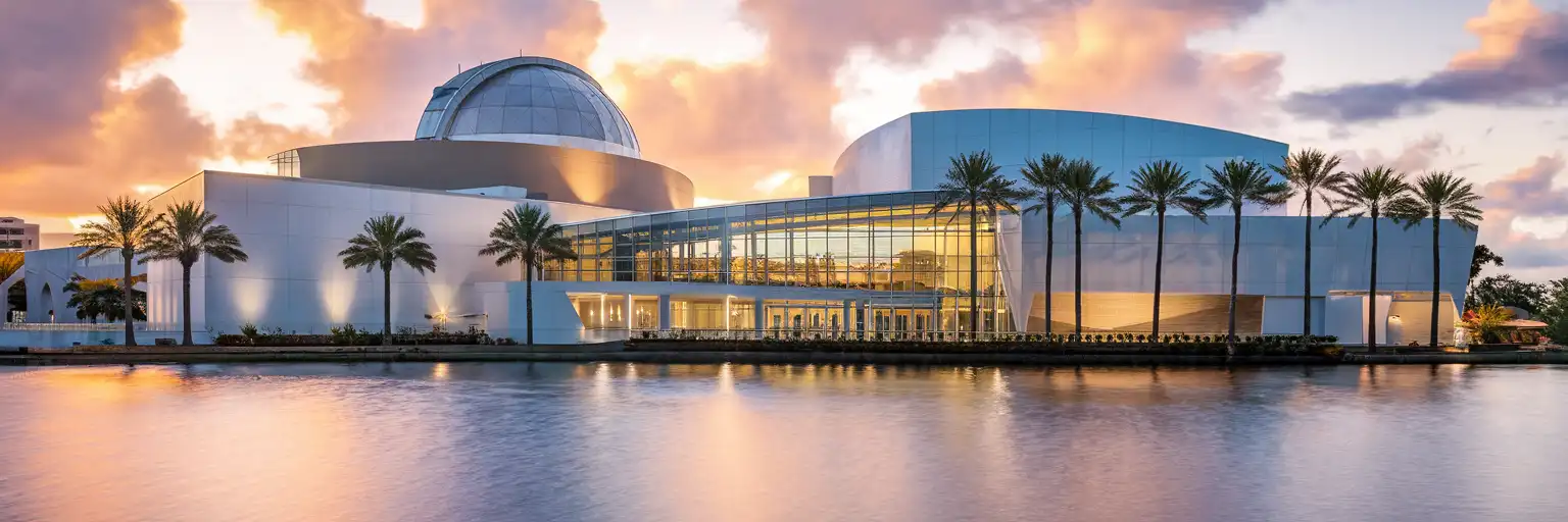 Orlando Science Center exterior with observatory dome and modern glass atrium at golden hour, palm trees and Lake Ivanhoe visible