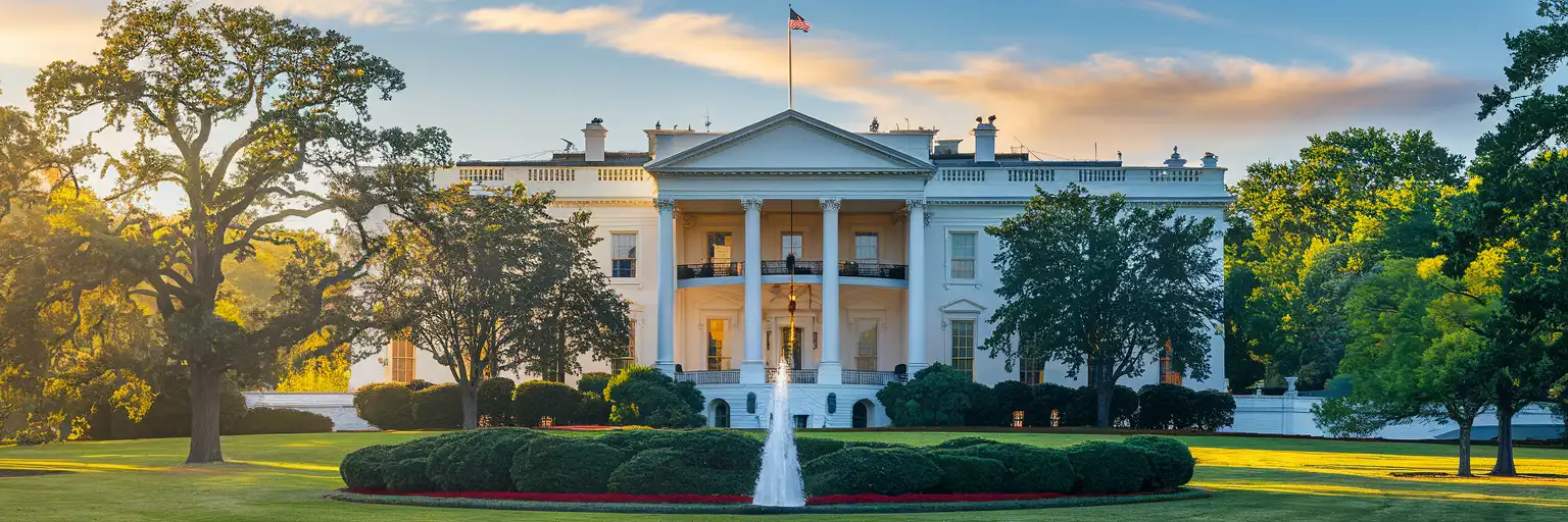 The White House North Portico at golden hour with neoclassical columns and American flag