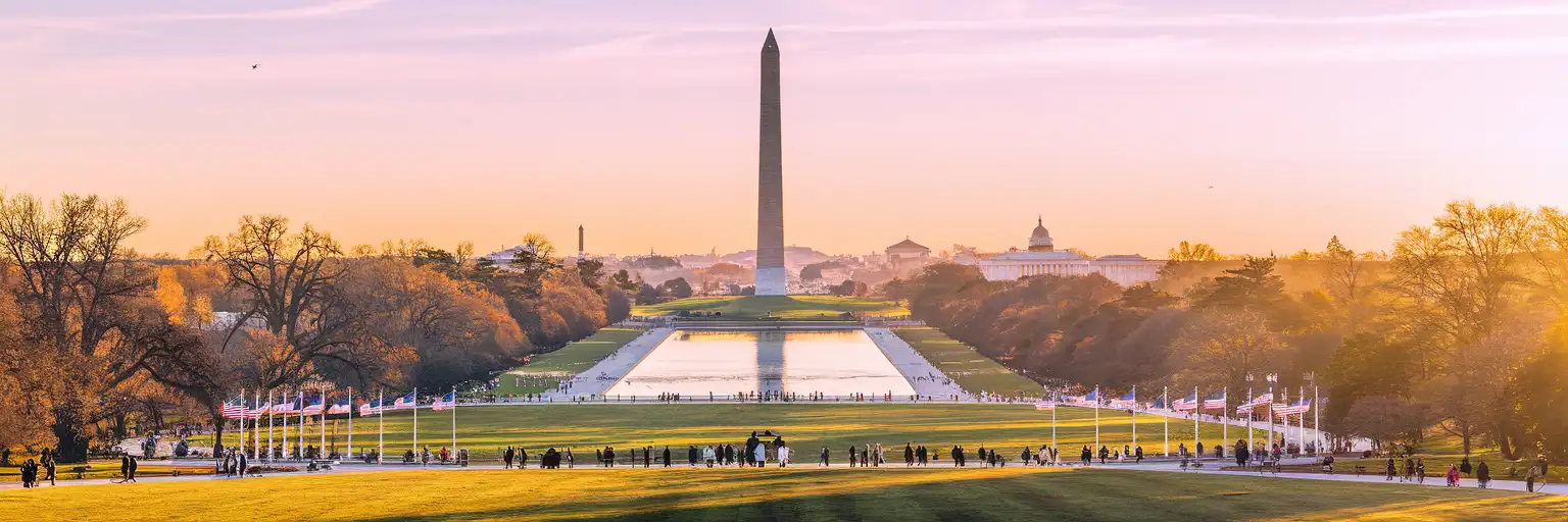 Monumento a Washington y Reflecting Pool en el National Mall al atardecer con el Monumento a Lincoln a lo lejos